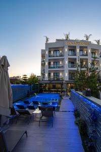 a hotel with tables and chairs in front of a building at Duka's Boutique Hotel in Ksamil