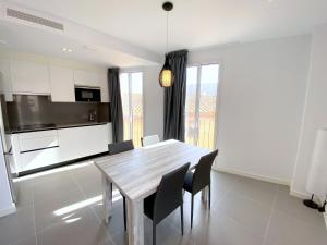 a kitchen and dining room with a wooden table and chairs at can Calo 3B in Castelló d'Empúries +9 photos