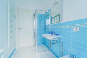 a blue tiled bathroom with a sink and a shower at Nestly house Portovenere in Portovenere +3 photos