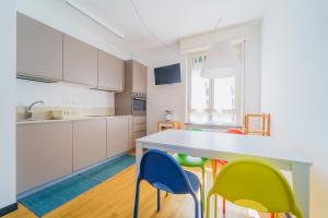 a kitchen with a table and colorful chairs at Nestly house Portovenere in Portovenere