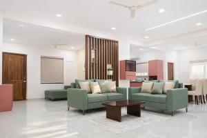a living room with two green couches and a table at Chitrapuri - 3BHK Spacious Flat, Gachibowli Only for Families in Gachibowli