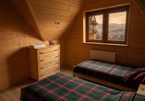 a bedroom with two beds and a window in a cabin at Hole in Zakopane