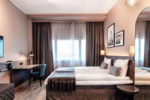 a hotel room with a bed and a desk at Scandic Helsinki Airport in Vantaa