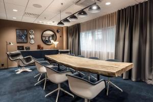 a conference room with a wooden table and chairs at Scandic Helsinki Airport in Vantaa