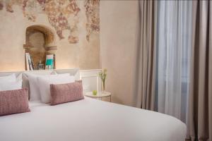a bedroom with a white bed and a window at NH Collection Palazzo Verona in Verona