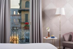 a hotel room with a bed and a balcony at NH Collection Palazzo Verona in Verona