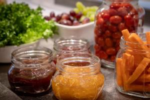 a table with jars of jam and fruits and vegetables at Scandic Veromies in Vantaa