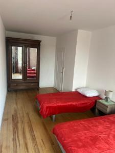 a room with two beds with red sheets and a window at Chez Bobby in Montréal