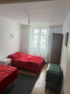 a bedroom with two beds and a red blanket at Chez Bobby in Montréal