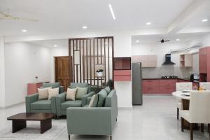 a living room with two couches and a kitchen at Chitrapuri - 3BHK Spacious Flat, Gachibowli Only for Families in Gachibowli