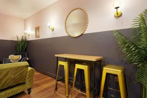 a room with a table and two yellow stools at Chic Retreat with King Bed in Barnard Castle in Barnard Castle