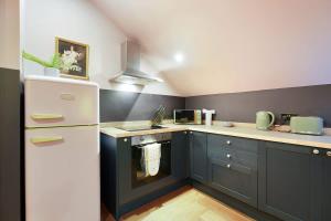 a kitchen with blue cabinets and a white refrigerator at Chic Retreat with King Bed in Barnard Castle in Barnard Castle +25 photos