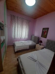 a bedroom with two beds and a couch and a window at George's Ap Gjirokastër in Gjirokastër