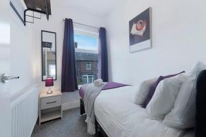 a bedroom with a white bed and a window at Spacious 4BR on Leafield Rd in Darlington