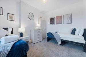 a bedroom with two beds and a dresser at Spacious 4BR on Leafield Rd in Darlington