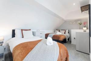 two beds in a room with white walls at Spacious 4BR on Leafield Rd in Darlington