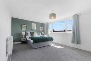 a bedroom with a bed and a large window at Spacious! 6BR in Beach Road in South Shields