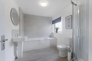 a white bathroom with a sink and a toilet at Spacious! 6BR in Beach Road in South Shields
