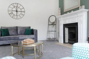 a living room with a couch and a table and a fireplace at Spacious! 6BR in Beach Road in South Shields