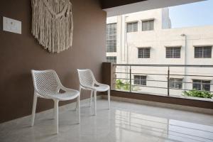 two white chairs in a room with a window at Chitrapuri - 3BHK Spacious Flat, Gachibowli Only for Families in Gachibowli