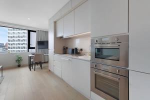 a kitchen with white cabinets and stainless steel appliances at Stylish Studio With Wi-Fi and Shared Spa Facilities in Manchester