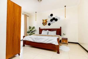 a bedroom with a large bed and a white wall at Relaxing Lodge in Kigali
