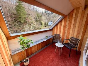 a balcony with two chairs and a table and a window at Äuchen am Rosenthal in Monschau +48 photos