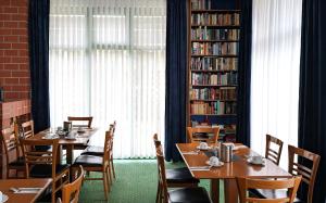 a restaurant with tables and chairs and bookshelves at ACRON Hotel Wittenberg in Lutherstadt Wittenberg