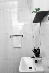 a white bathroom with a sink with a plant on it at Relaxing Lodge in Kigali +34 photos