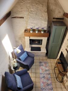 a living room with blue couches and a fireplace at Domaine Bel Air 855 - Gîte Belle in Saint-Denis-de-Villenette