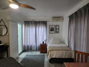 a bedroom with a bed and a window with curtains at Groenewald's Haven in Nelspruit