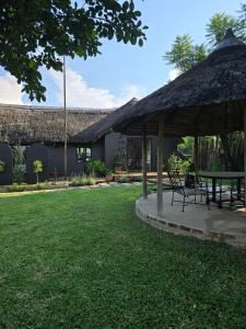 a pavilion with a table and chairs in a yard at The House On The Hill in Lanseria