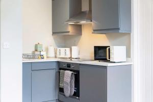 a kitchen with blue cabinets and white appliances at Flat1 1BR in Horsemarket in Barnard Castle