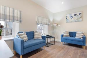 a living room with two blue couches and a table at Flat3 1BR in Horsemarket in Barnard Castle