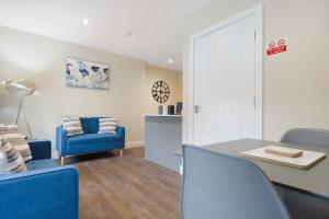 a living room with blue chairs and a table at Flat3 1BR in Horsemarket in Barnard Castle