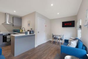 a living room with a blue couch and a kitchen at Flat3 1BR in Horsemarket in Barnard Castle
