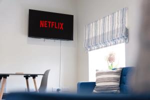 a living room with a netflix sign on the wall at Flat3 1BR in Horsemarket in Barnard Castle +15 photos