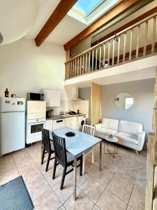 a kitchen and living room with a table and chairs at Maison individuelle Hourtin centre jardin clos in Hourtin