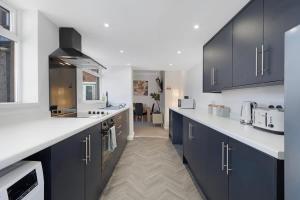 a kitchen with black cabinets and white counter tops at New! 4BR in Durham Road in Annfield Plain