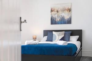 a bedroom with a blue and white bed with a cross at New! 4BR in Durham Road in Annfield Plain