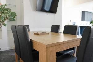 a wooden table with black chairs around it at New! 4BR in Durham Road in Annfield Plain +36 photos