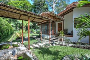 a house with a garden in front of it at Uva Blue Villas - Zen Villa 1 - 3 Bedroom Villa, Private Garden & Yoga Deck in Puerto Viejo