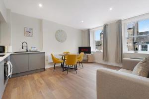a living room with a table and yellow chairs at Flat2 2BR in Horsemarket in Barnard Castle