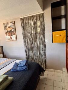 a room with a bed with a curtain and a bed sidx sidx sidx at le Cottage in Le Moule