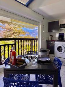 a kitchen with a table and chairs and a balcony at le Cottage in Le Moule