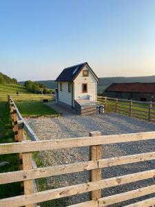 a small house in a field next to a fence at The Niblet Bonnie View Glamping Cabins, Helmsley in Carlton