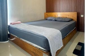 a bed with a wooden headboard in a room at Sanga Hotel in Gabung