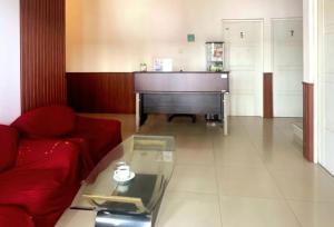 a living room with a piano and a red couch at Sanga Hotel in Gabung
