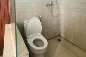 a bathroom with a toilet and a shower at Sanga Hotel in Gabung