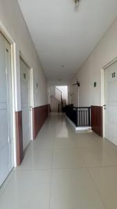 an empty hallway of a building with white floors at Sanga Hotel in Gabung